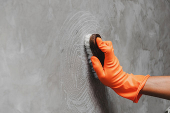 手男人。穿橙色<strong>橡胶手套</strong>使用转换擦洗清洁的混凝土墙