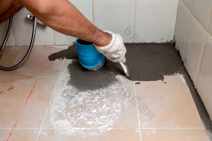 建设工人是刷牙防水水泥瓷砖地板的浴室