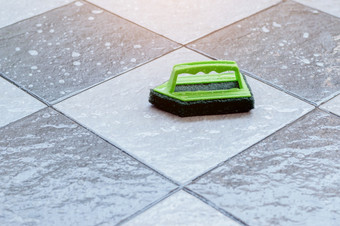 关闭绿色塑料刷为擦洗和<strong>清洁</strong>地板放置湿平铺的地板上