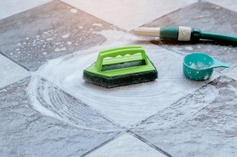 关闭的绿色塑料刷为擦洗和清洁的地板<strong>上放</strong>置的湿<strong>瓷砖</strong>地板<strong>上</strong>和泡沫与洗涤剂