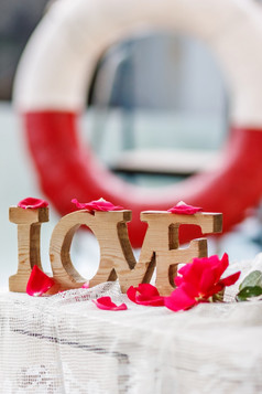 爱节省了的世界情人节rsquo一天雕刻木词爱在粉红色的玫瑰花瓣的背景生活浮标