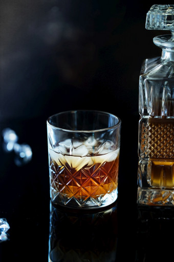 玻璃威士忌波<strong>本</strong>威士忌与冰黑色的石头表格玻璃威士忌与冰和广场玻璃水瓶玻璃苏格兰威士忌威士忌和冰