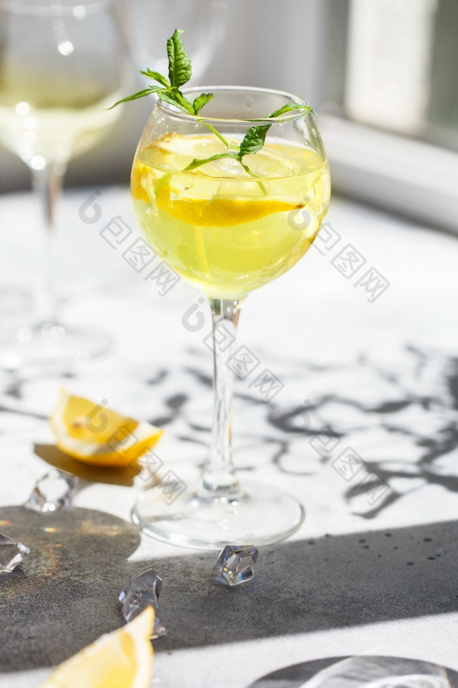 丽塔·哈鸡尾酒与柠檬片的玻璃柠檬水莫吉托鸡尾酒与柠檬和薄荷冷让人耳目一新喝饮料与冰自制的Limoncello玻璃薄腿
