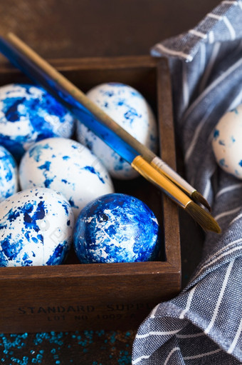 染色复活节鸡蛋拉西奇蓝色的复活节鸡蛋的棕色（的）背景蓝色的斑点复活节鸡蛋与油漆和刷装修鸡蛋准备为复活节