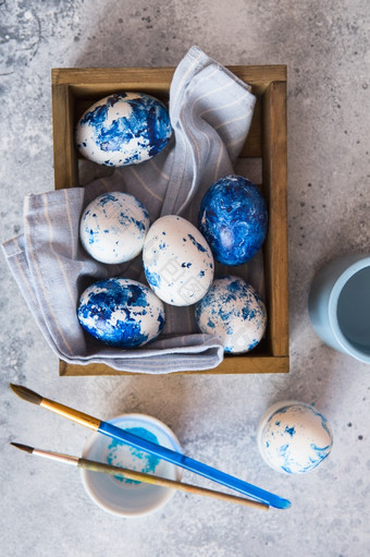 染色复活节鸡蛋拉西奇蓝色的复活节鸡蛋的灰色背景蓝色的斑点复活节鸡蛋与油漆和刷装修鸡蛋准备为复活节