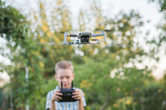 孩子飞行无人机男孩操作drones孩子操作四轴飞行器小飞行员使用无人机远程控制器