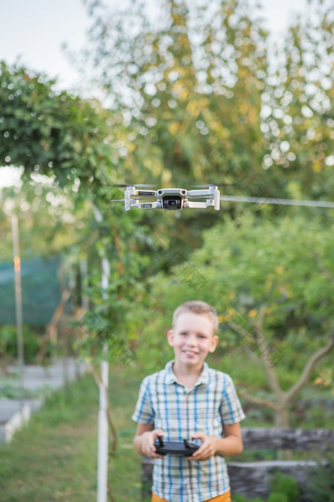 孩子飞行无人机男孩操作drones孩子操作四轴飞行器小飞行员使用无人机远程控制器