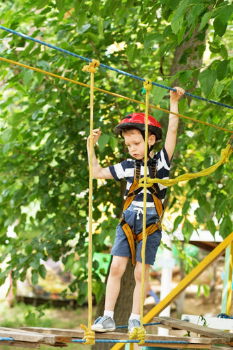 孩子们攀爬冒险公园男孩享受攀爬的绳子课程冒险孩子攀爬高线公园快乐男孩玩冒险公园持有绳子和攀爬木楼梯