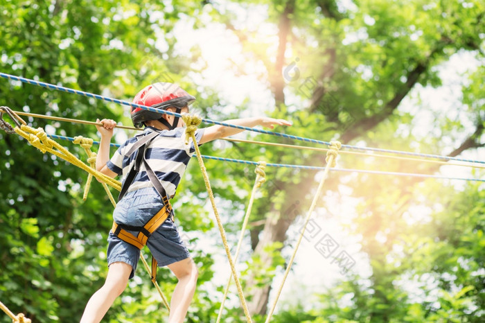 孩子们攀爬冒险公园男孩享受攀爬的绳子课程冒险孩子攀爬高线公园快乐男孩玩冒险公园持有绳子和攀爬木楼梯