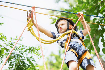 孩子们攀爬冒险公园<strong>男孩</strong>享受攀爬的绳子课程冒险孩子攀爬高线公园<strong>快乐男孩</strong>玩冒险公园持有绳子和攀爬木楼梯