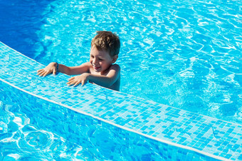 快乐孩子玩蓝色的水游泳池小男孩学习游泳夏天假期概念可爱的男孩游泳池水孩子溅和有有趣的游泳池