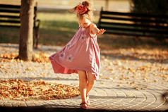 完整的长度肖像小女孩跳舞的公园温暖的秋天晚上移动
