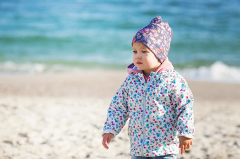 可爱的小女孩玩的桑迪海滩快乐孩子穿温暖的花打印夹克砰的一声砰的一声他和围巾玩在户外秋天冬天春天一天家庭享受冬天走自然