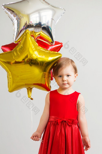 小婴儿女孩持有<strong>气球</strong>的形式星星年轻的女孩持有明星形状的<strong>气球</strong>快乐孩子与色彩斑斓的闪亮的箔<strong>气球</strong>对白色背景