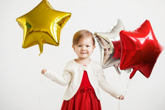 小婴儿女孩持有气球的形式星星年轻的女孩持有星形的气球快乐孩子与色彩斑斓的闪亮的箔气球对白色背景