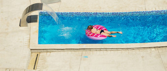 快乐孩子玩蓝色的水游泳池热带度假胜地的海夏天假期概念可爱的女孩游泳池水孩子与游泳设备充气游泳圆