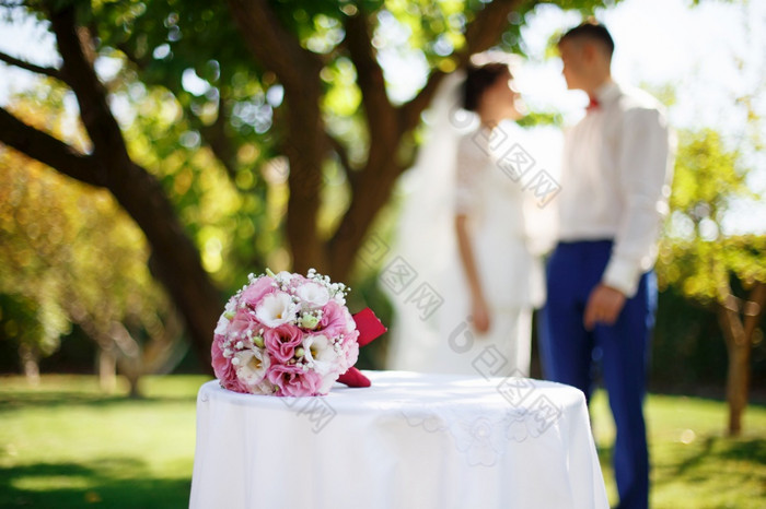婚礼新娘花束与粉红色的和白色花的表格的花园对的背景的新娘和新郎婚礼概念