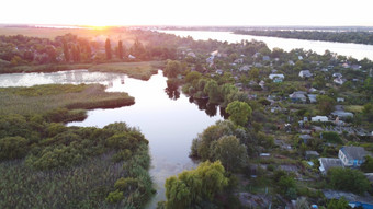 无人机飞在挥舞着河包围当地的村与各种各样的建筑和湿地和沼泽栖息地与芦苇床常见的里德空中视图火里德沼泽