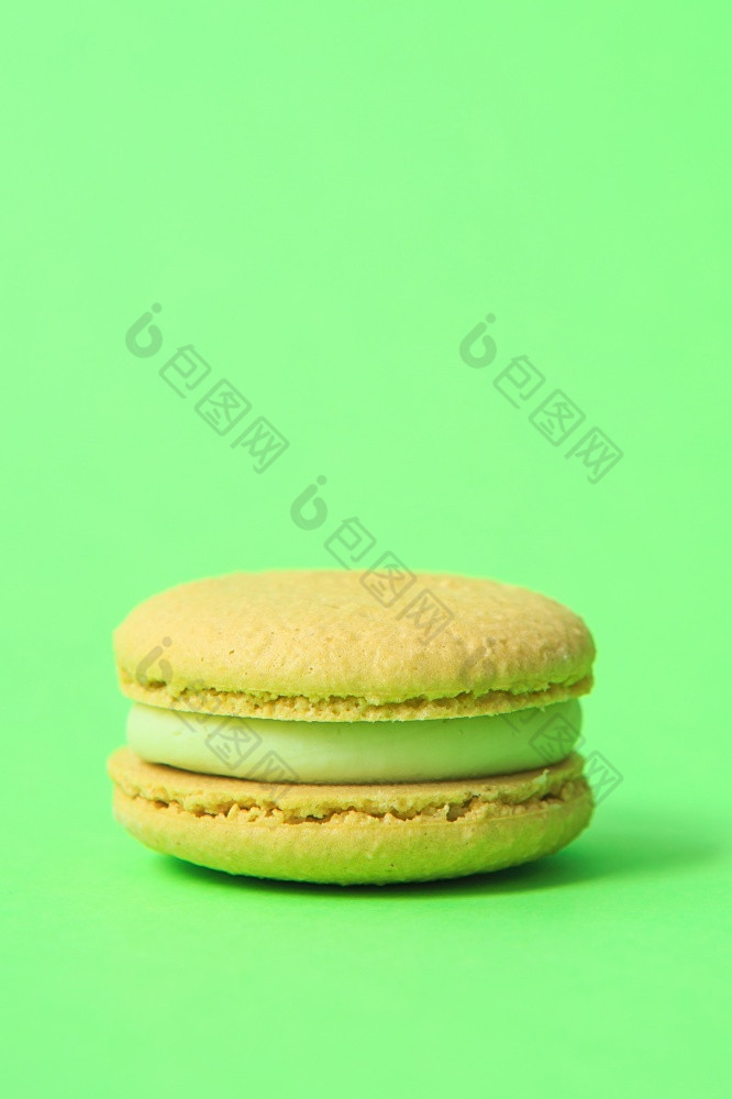 黄色的蛋糕macaron蛋白杏仁饼干绿色背景色彩斑斓的杏仁饼干法国蛋白杏仁饼干蛋糕特写镜头蛋白杏仁饼彩色的背景
