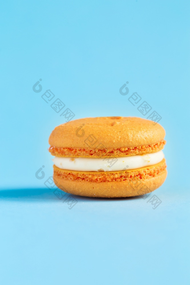 橙色蛋糕macaron蛋白杏仁饼干蓝色的背景色彩斑斓的杏仁饼干法国蛋白杏仁饼干蛋糕特写镜头蛋白杏仁饼彩色的背景