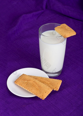 玻璃牛奶和饼干紫罗兰色的背景玻璃牛奶和饼干