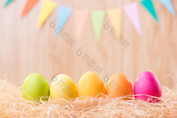 快乐复活节一天色彩斑斓的鸡蛋巢与模糊庆祝横幅聚会，派对旗帜与复制空间