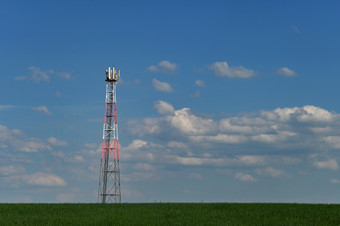 发射机为GSM信号移动手机的场的背景蓝色的天空与云概念为现代技术和行业电信塔