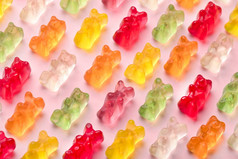 色彩斑斓的橡皮糖熊模式在粉红色的背景特写镜头图像