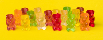 多色水果橡皮糖糖果的形式灰熊熊果冻熊在黄色的背景全景图像