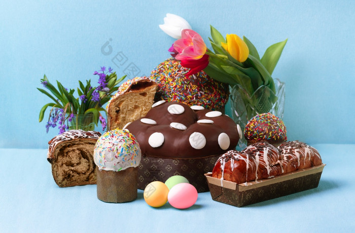 复活节蛋糕和春天花复活节面包和鸡蛋在蓝色的背景