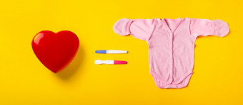 心怀孕测试和婴儿衣服快乐母亲规划概念全景图像