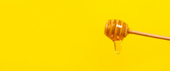 蜂蜜滴从蜂蜜七星黄色的背景厚蜂蜜浸渍从的木蜂蜜勺子健康的食物和饮食概念