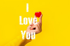 小红色的心手在黄色的背景图像与登记爱你