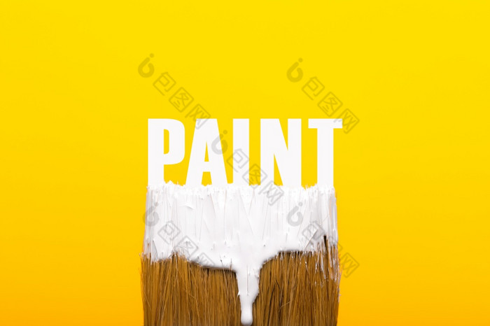 画笔与白色油漆在黄色的背景修复和绘画工具概念
