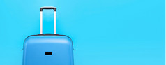 蓝色的旅行手提箱在蓝色的背景全景模拟图像