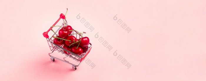 购物车完整的成熟的樱桃健康的和有营养的购物完整的维生素饲料孩子们与水果在粉红色的背景