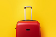 红色的旅行手提箱关闭在黄色的背景