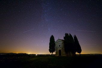 意大利托斯卡纳孤独的教堂和柏树树场晚上天空与<strong>无数</strong>的人星星布满星星的天空在教堂