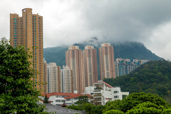 中国多云的一天在香港香港住宅摩天大楼对的背景树木繁茂的山和低云摩天大楼多山的在香港香港