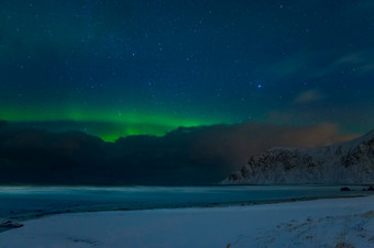 冬天挪威晚上海滩在<strong>的</strong>山罗弗敦群岛星星<strong>的蓝色的</strong>天空和极光北欧化工以上<strong>的</strong>云冬天海滩和星星和极光北欧化工