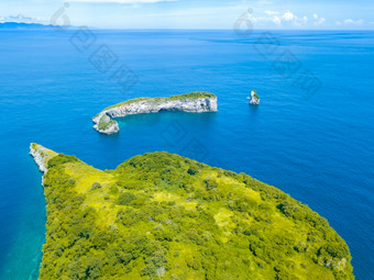 印尼小岩石热带岛屿杂草丛生的与丛林和Azure水的海洋空中视图小岛屿与丛林的海洋空中视图