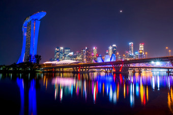 新加坡市中心与沙子酒店摩天大楼和两个桥梁月亮和美丽的晚上照明晚上和月亮在新加坡市中心