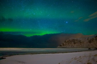 <strong>挪</strong>威罗弗敦群岛晚上冬天海滩的峡湾包围白雪覆盖的山在那里是许多星星的天空云和北部灯极光北欧化工在的冬天<strong>挪</strong>威海滩