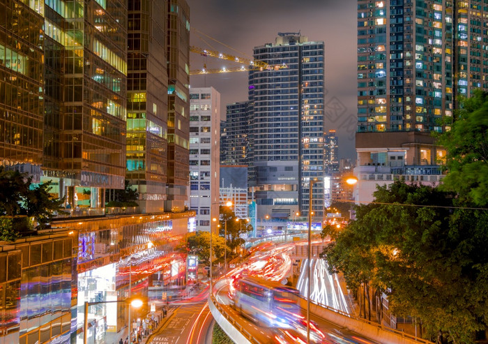 晚上在香港香港摩天大楼和绿色树强大的交通晚上街在香港香港与摩天大楼和交通