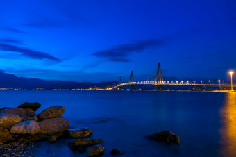 希腊斜拉桥桥在的海湾哥林多rion-antirion晚上天空在的山海岸希腊桥里翁抗尿酸晚上