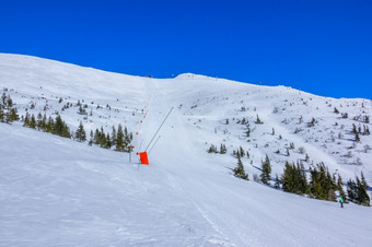 阳光明媚的天气的滑雪度假胜地蓝色的天空长和直滑<strong>雪坡</strong>与雪大炮滑<strong>雪坡</strong>阳光明媚的天气