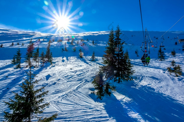 冬天斯洛伐克滑雪度假胜地明亮明亮的太阳在无能力的滑雪坡视图从的椅子电梯明亮的太阳在无能力的滑雪坡和椅子电梯