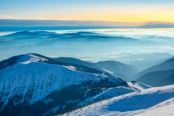 冬天阳光明媚的一天的前的山许多山山峰包围光雾山山峰和雾的山谷冬天阳光明媚的一天
