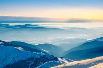 的上衣冬天山和光雾的山谷阳光明媚的天气和蓝色的天空冬天山和光雾