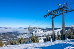 斯洛伐克语滑雪度假胜地明亮雪闪烁的太阳蓝色的天空和光雾之间的的山山峰椅子滑雪电梯椅子电梯和光雾之间的山峰